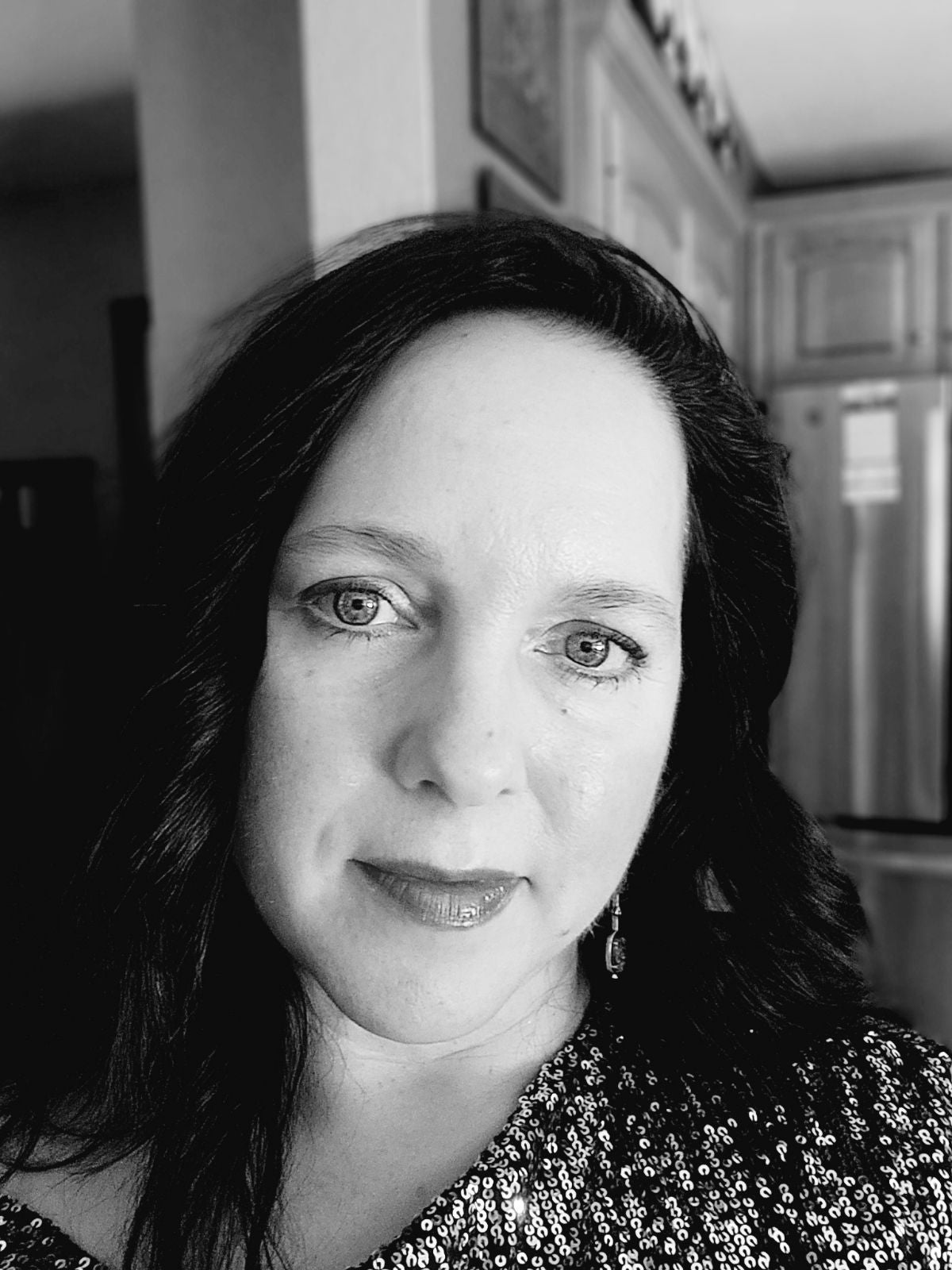 Black and white photo of a woman with a blurred indoor background